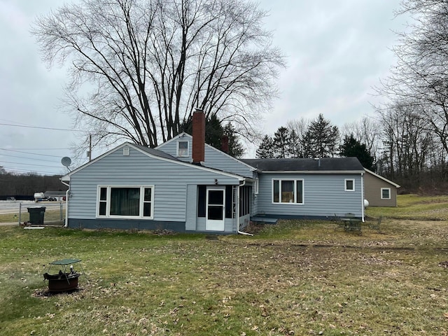 back of house with a lawn and a chimney