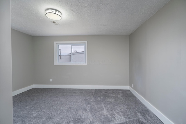 unfurnished room featuring carpet, visible vents, and baseboards