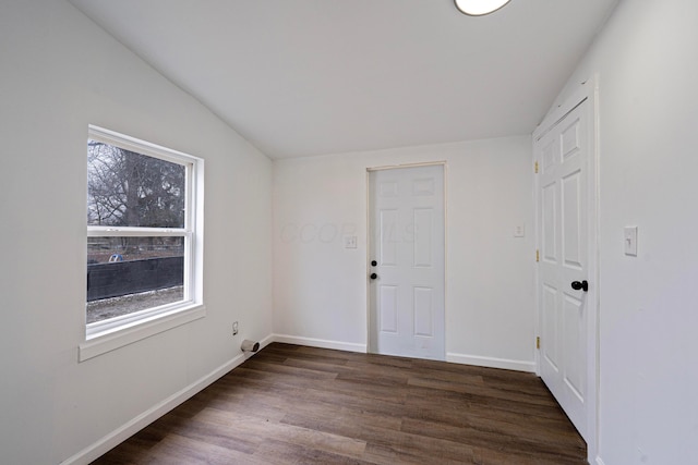 spare room with baseboards and wood finished floors