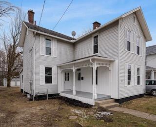 view of front of house featuring a porch and a chimney