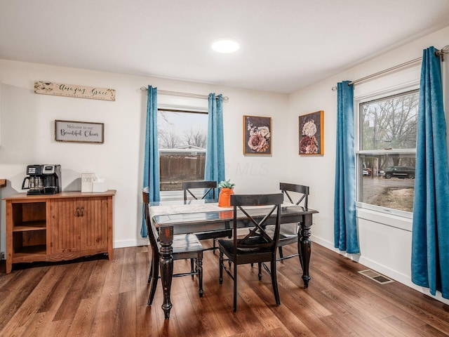 dining area with visible vents, baseboards, and wood finished floors