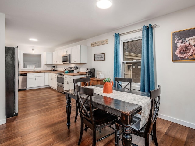 dining space with baseboards and dark wood-type flooring