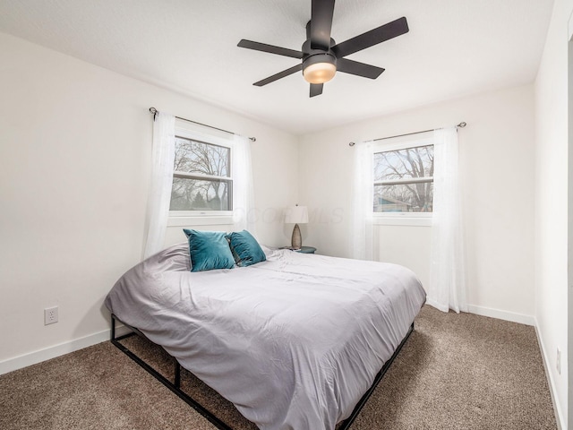 carpeted bedroom with multiple windows, baseboards, and a ceiling fan