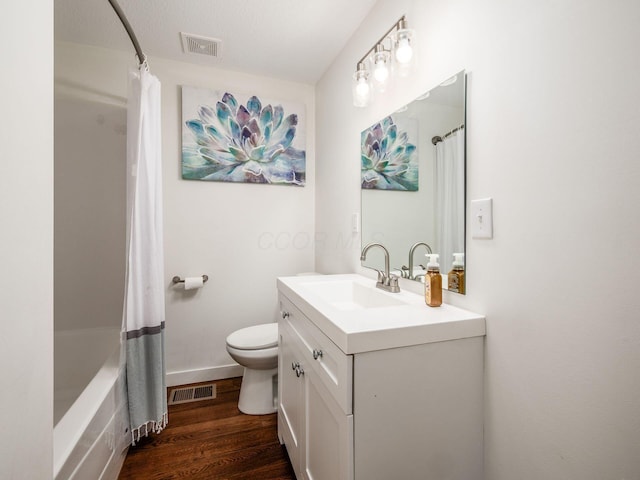 bathroom with visible vents, vanity, toilet, and wood finished floors