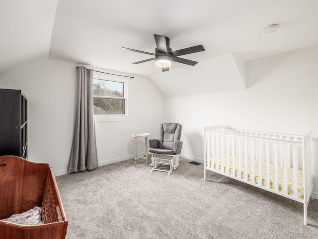 bedroom with lofted ceiling, carpet floors, a crib, and baseboards