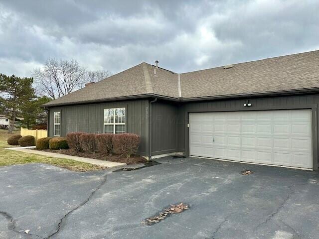 view of home's exterior featuring a garage, driveway, and roof with shingles