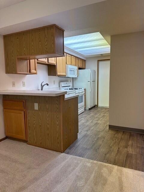 kitchen featuring open shelves, light countertops, white appliances, a peninsula, and baseboards