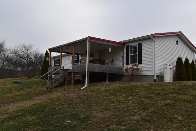 back of property with stairs and a yard