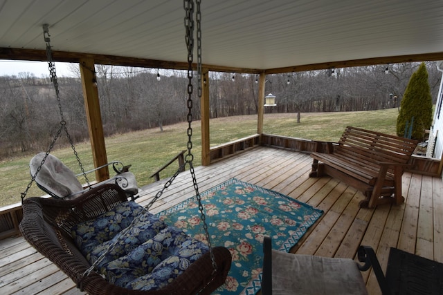 deck with a wooded view and a lawn