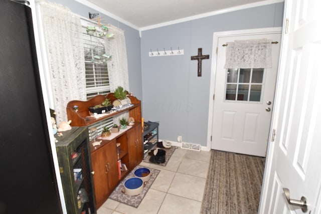 entryway with visible vents, crown molding, and light tile patterned flooring