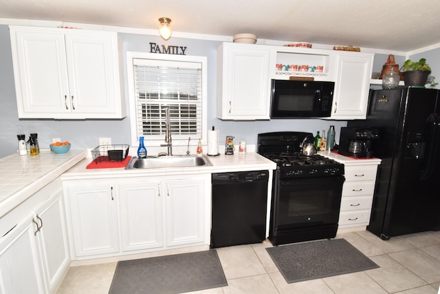 kitchen featuring black appliances, a sink, and white cabinetry