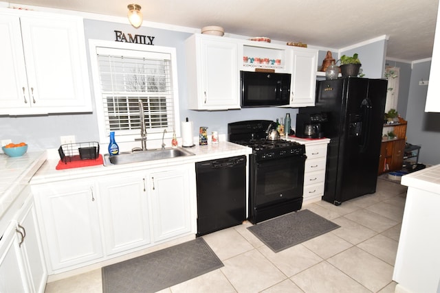 kitchen featuring ornamental molding, white cabinets, a sink, light tile patterned flooring, and black appliances