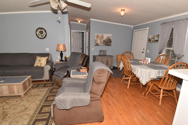 living room with light wood-type flooring, a ceiling fan, and crown molding