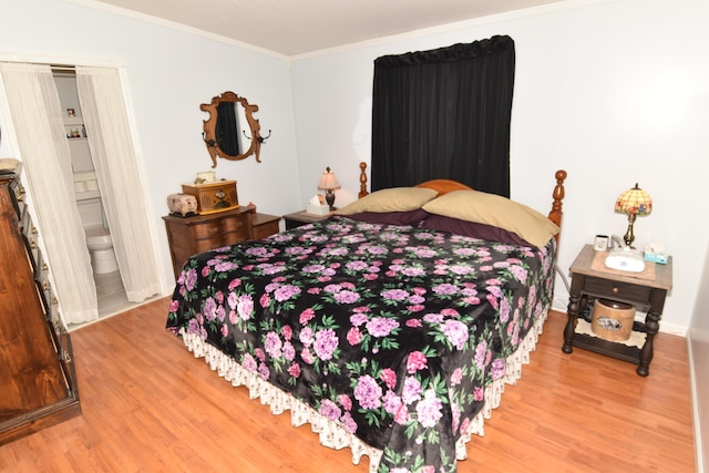 bedroom with ornamental molding and wood finished floors