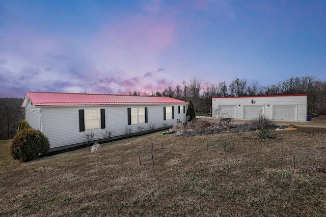 view of front facade with a front yard, a garage, and metal roof