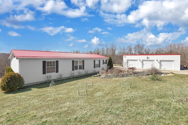 exterior space featuring metal roof, a detached garage, and a front lawn