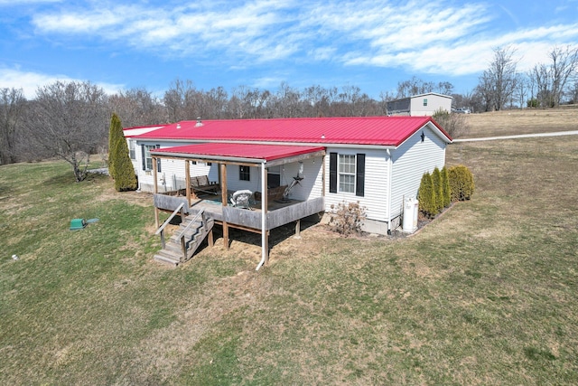 back of property with a lawn, metal roof, and a deck