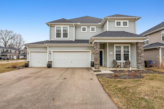 view of front of home with a garage, stone siding, roof with shingles, and driveway