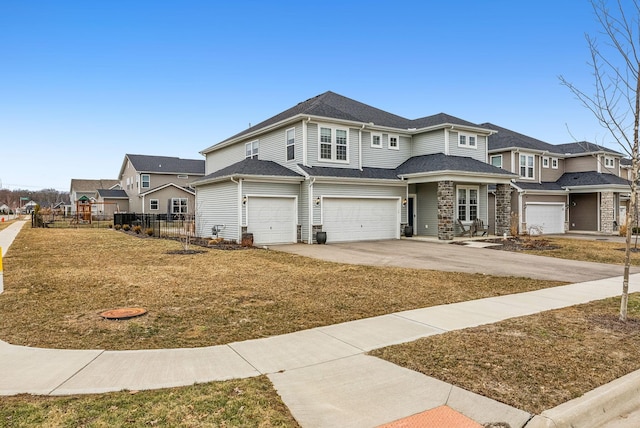 view of front of property featuring fence, a residential view, a garage, stone siding, and driveway