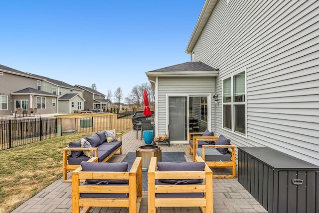 view of patio / terrace featuring a residential view, an outdoor living space with a fire pit, and fence