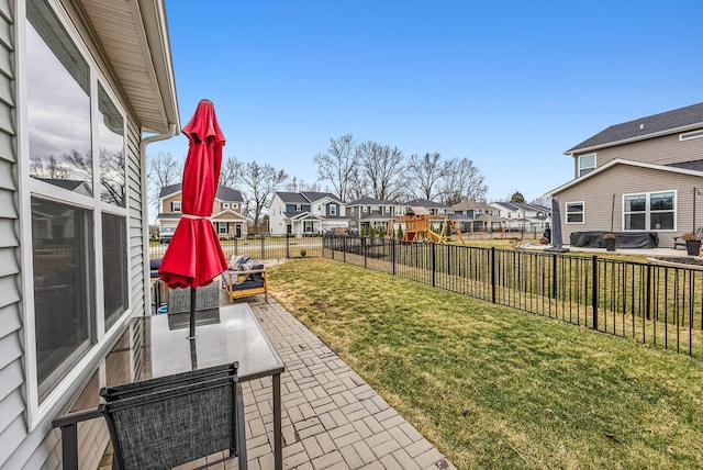 view of yard featuring a patio area, a residential view, a fenced backyard, and a playground