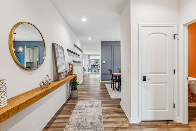 hallway featuring recessed lighting, baseboards, and wood finished floors