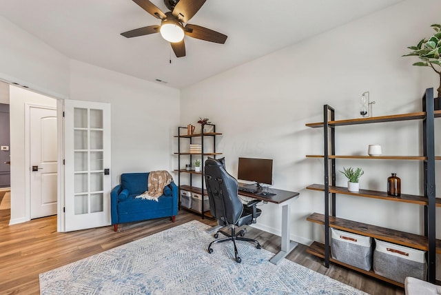 office area featuring ceiling fan, visible vents, baseboards, and wood finished floors