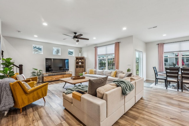 living room featuring visible vents, baseboards, recessed lighting, light wood-style flooring, and a ceiling fan