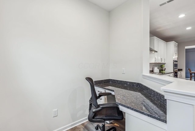 home office with visible vents, wood finished floors, built in desk, recessed lighting, and baseboards