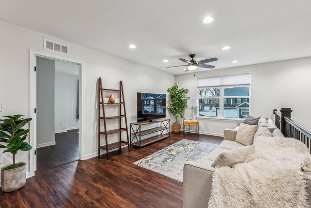 living room with recessed lighting, visible vents, baseboards, and wood finished floors