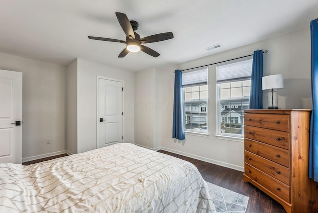 bedroom featuring visible vents, baseboards, a ceiling fan, and dark wood-style flooring