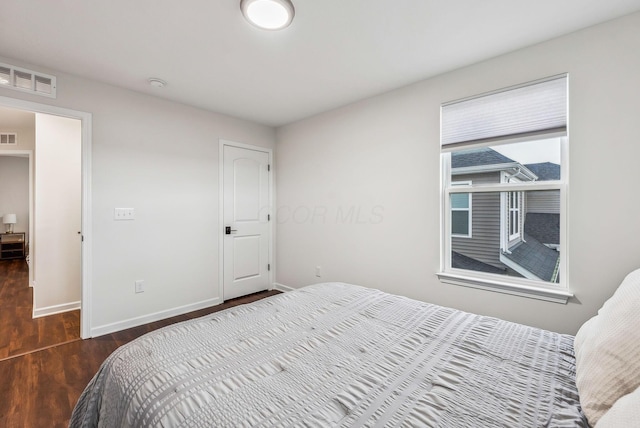 bedroom featuring visible vents, wood finished floors, and baseboards