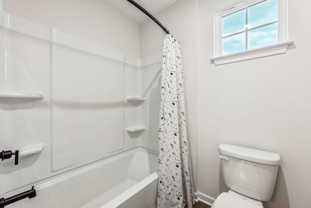 bathroom featuring toilet, shower / tub combo with curtain, and baseboards