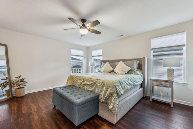 bedroom with visible vents, a ceiling fan, baseboards, and wood finished floors