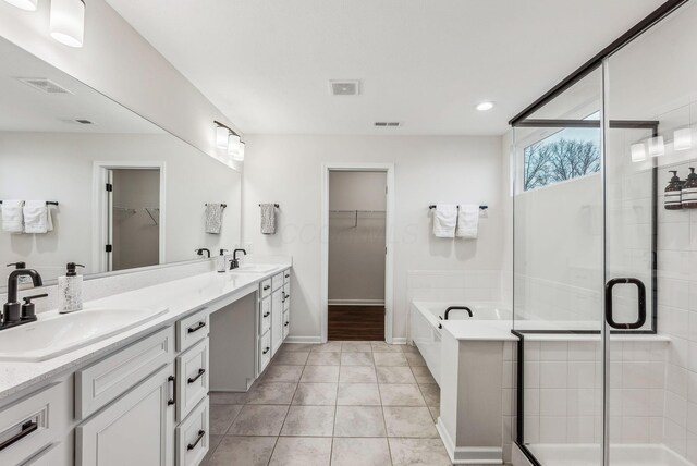 full bathroom featuring a sink, visible vents, a garden tub, and a shower stall