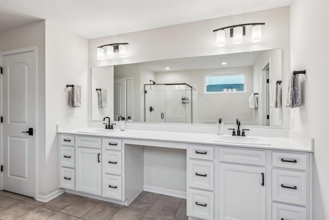 bathroom featuring double vanity, tile patterned flooring, a shower stall, and a sink