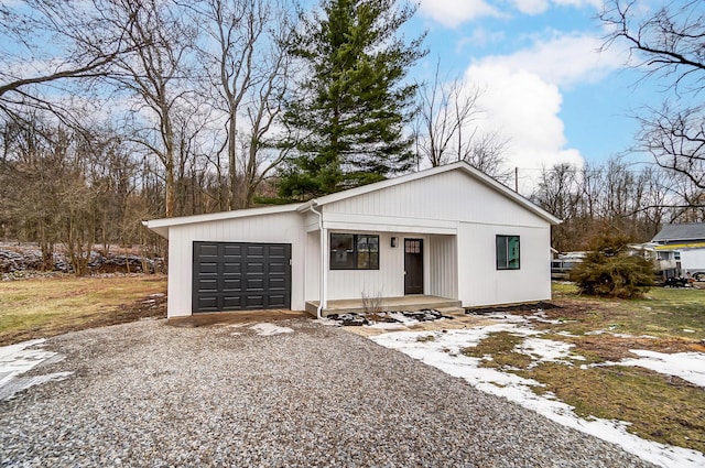 view of front facade with driveway, a porch, and an attached garage