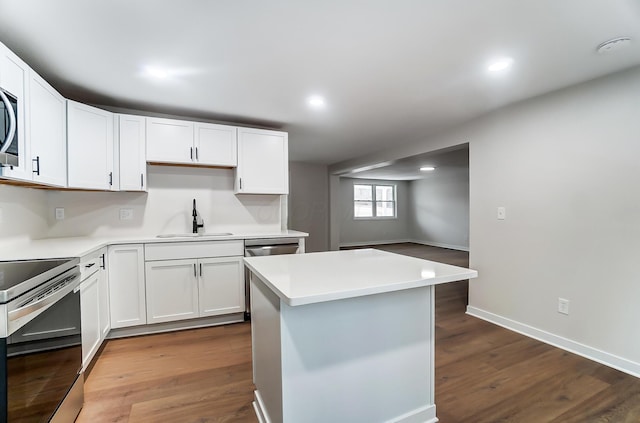 kitchen featuring stainless steel appliances, a center island, a sink, and dark wood-style floors