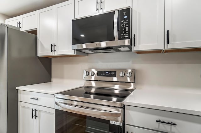 kitchen with appliances with stainless steel finishes, light countertops, and white cabinetry