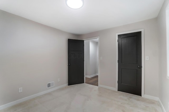 unfurnished bedroom with carpet, baseboards, and visible vents