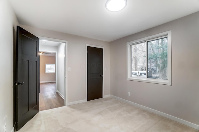 bedroom with light carpet and baseboards