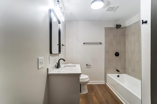 bathroom featuring toilet, wood finished floors, vanity, visible vents, and baseboards