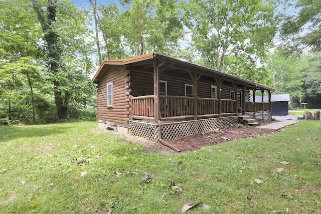 log home with a porch, a front lawn, and log siding