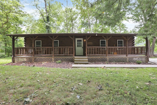 rear view of property featuring a porch, a lawn, and log exterior