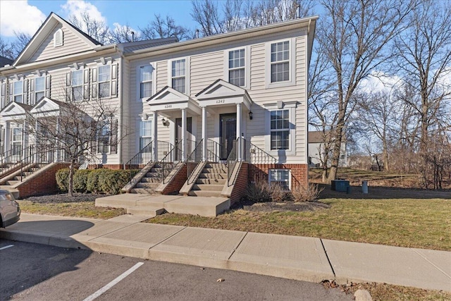 view of property with a front yard and uncovered parking