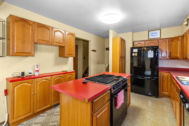 kitchen featuring black appliances, brown cabinets, a sink, and a center island