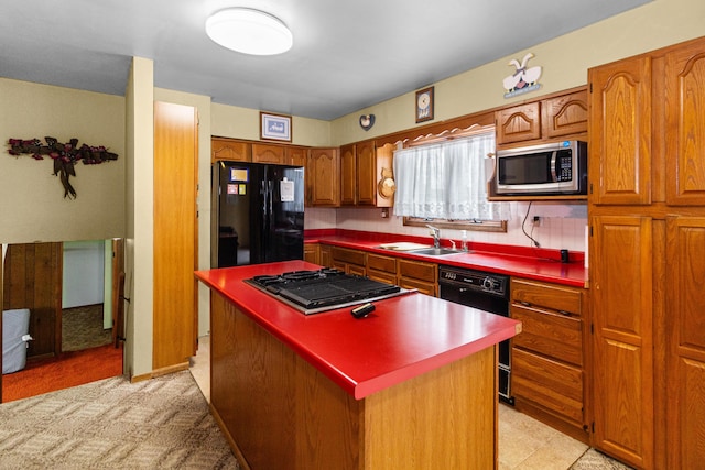 kitchen featuring black appliances, a kitchen island, a sink, and brown cabinetry