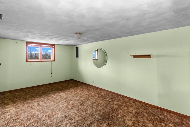 basement with visible vents, carpet flooring, a textured ceiling, and baseboards