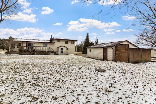 back of property with an outdoor structure and a wooden deck