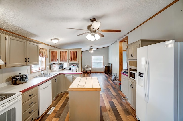 kitchen featuring white appliances, a kitchen island, dark wood-type flooring, light countertops, and a sink